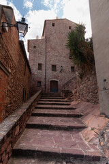 Fototapeta na wymiar Cobbled staircase between stone houses in the center of Vilafamés in Castellón (Spain) that ascend to the upper part of the town