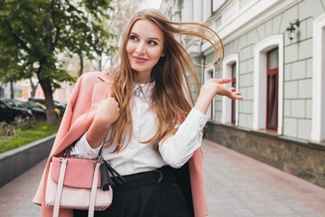 cute attractive stylish smiling woman walking city street in pink coat spring fashion trend holding...