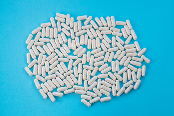 Light capsules are scattered on a blue background. The concept of vitamins, dietary supplements....