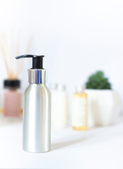 Recyclable metallic cosmetic face cleanser bottle with pump in the bathroom close up. Body wash concept