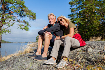 Senior hiking couple looking in the camera in the Swedish archipelago