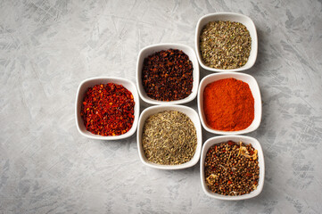 Obraz na płótnie Canvas Spices in bowls on a gray concrete background.