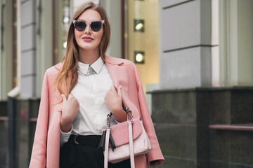 attractive stylish smiling rich woman walking city street in pink coat spring fashion trend holding...