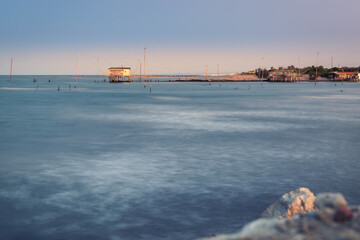 Fishing huts with typical italian fishing machine called  trabucco ,at wonderful sunset .Lido di...