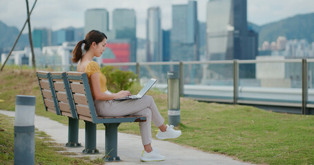 Woman work on laptop computer at park
