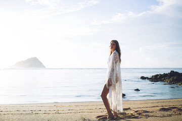 Young woman in beachwear standing on peaceful shore