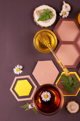 Top view banner template with Honey in Jar and in a glass bowl with a yellow plastic dipper on a brown background with paper honeycomb.