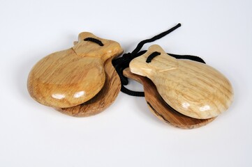 Spanish wooden castanets against a plain background.