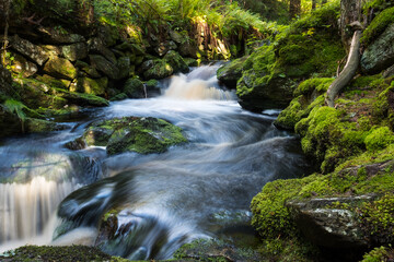 waterfall in the forest, long exposure of the stream in nature park, sumava, modrava, czech republic