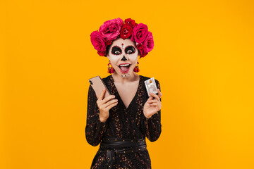Photo of girl in halloween makeup posing with cellphone and credit card