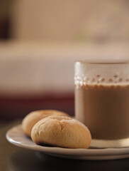 Cookies and coffee in a white plate. Coffee with milk in glass cup. Homemade cookies.