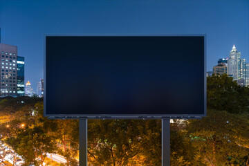 Blank black road billboard with Bangkok cityscape background at night time. Street advertising poster, mock up, 3D rendering. Front view. The concept of marketing communication to sell idea.