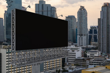Blank black road billboard with Bangkok cityscape background at sunset. Street advertising poster, mock up, 3D rendering. Side view. The concept of marketing communication to promote or sell idea.