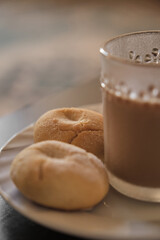 Cookies and coffee in a white plate. Coffee with milk in glass cup. Homemade cookies.