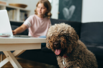 girl with her dog sitting in living room at home