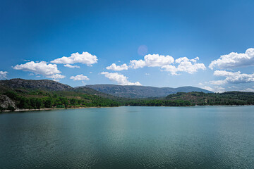 Fototapeta na wymiar Vista del lago con las montañas y cielo nublado de fondo