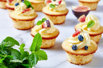 cupcakes with buttercream and berries on a table