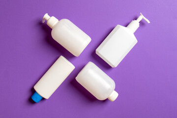 Set of White Cosmetic containers isolated on colored background, top view with copy space. Group of plastic bodycare bottle containers with empty space for you design