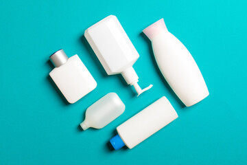 Set of White Cosmetic containers isolated on colored background, top view with copy space. Group of plastic bodycare bottle containers with empty space for you design