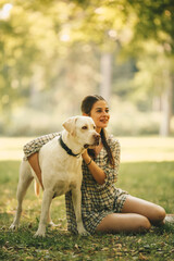 A young woman and her guard dog together in a meadow, the dog noticed something