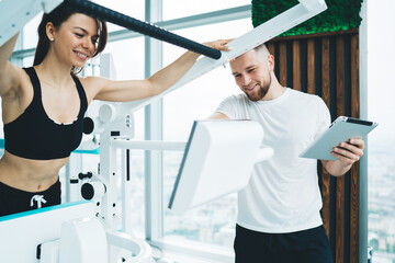 Cheerful woman doing exercises on machine