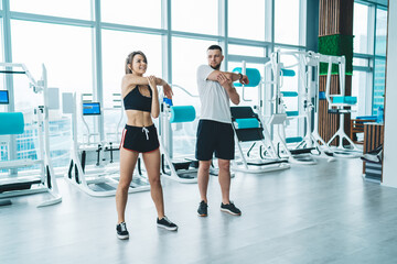 Cheerful sportspeople stretching in gym