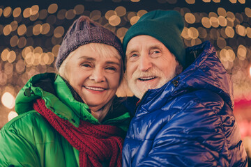 Adorable affectionate bonding two married people old woman man enjoy x-mas christmas jolly holly eve evening atmosphere walk under lights outdoors wear season coat headwear scarf