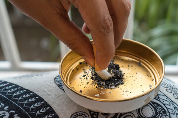 Woman smoking cigarette and using an ashtray