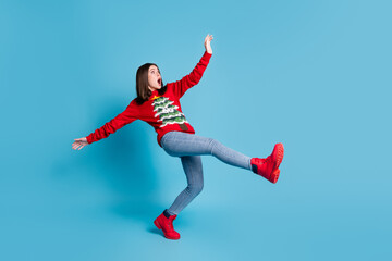 Fototapeta na wymiar Full body size photo of cute pretty lady stand tiptoe raise hands funny falling open mouth terrified mad look empty space wear red sweater jeans boots isolated blue color background