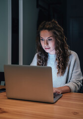 Woman working on laptop late at home stock photo