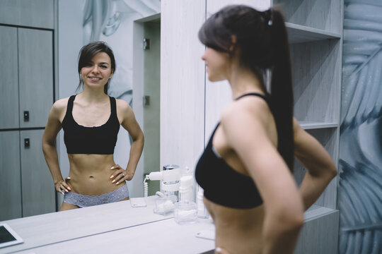 Portrait of smiling caucasian female looking at camera smiling satisfied with perfect body shape, happy pretty woman in underwear enjoying results of slimming and keeping healthy lifestyle