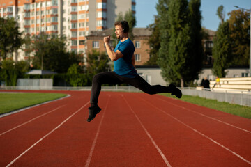Obraz premium Fitness man jumping at the stadium