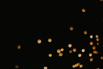 yellow round bokeh on a black background copy space. garland lights in the dark. holiday lighting.