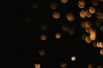 yellow round bokeh on a black background copy space. garland lights in the dark. holiday lighting.