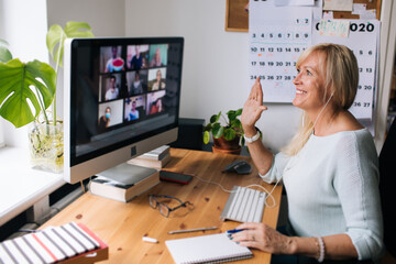 Blonde mature woman by computer.  Working from home office. Work life balance and goal setting....