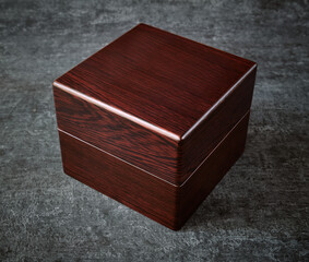 Beautiful wooden gift box of burgundy color, gray background, close up