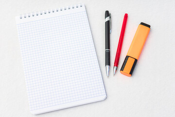 Notebook, pens and marker, top view, white background, copy space