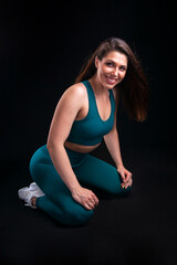 Fototapeta na wymiar woman athlete in sportswear posing in studio on black background