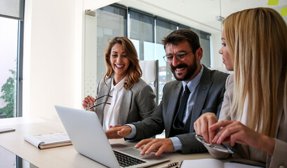 Colleagues sit at a desk in the office and analyze the work, they have found a solution for a new job
