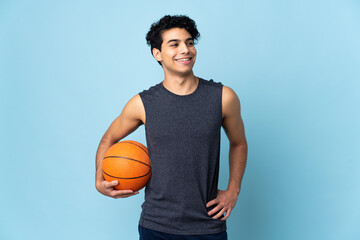 Venezuelan basketball player man over isolated background posing with arms at hip and smiling
