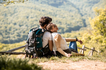 A young couple of mountaineers in nature, sitting and resting during hiking, day in nature
