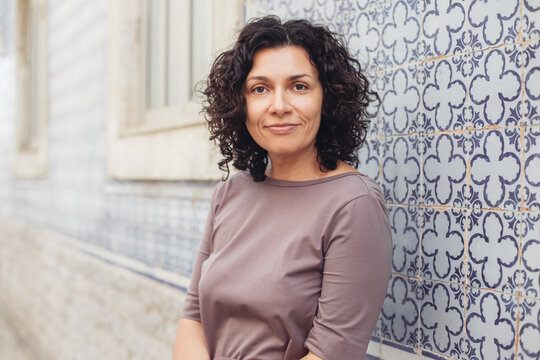A young pretty woman. Traditional Portuguese building with azulejo tiles on the background.