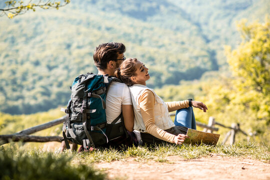 A young couple of mountaineers in nature, sitting and resting during hiking