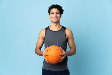 Young Venezuelan man isolated on blue background playing basketball