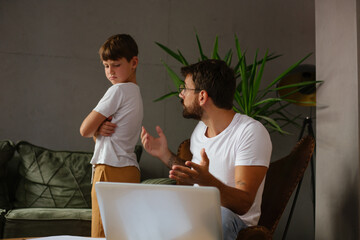 Father and son together in the living room, the father explains to the son that he currently has to work