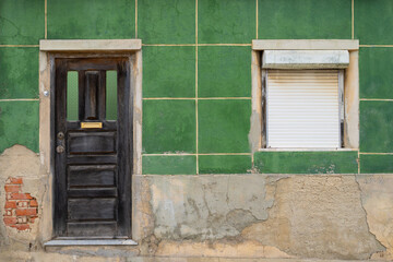Very old green wall with door and window