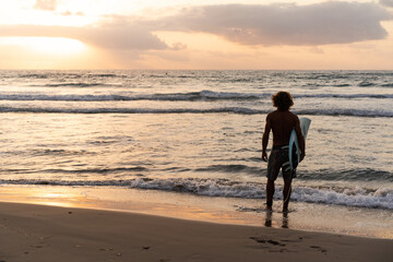 Young caucasian man get up early to  doing surf at sunrise