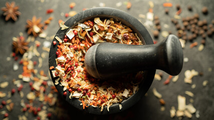 TOP VIEW: Grinding spices herbs in a mortar with pestle - obrazy, fototapety, plakaty
