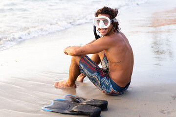 Young caucasian man getting ready to dive into the sea