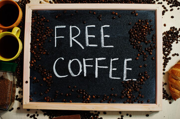 Free coffee. Words on blackboard flat lay.